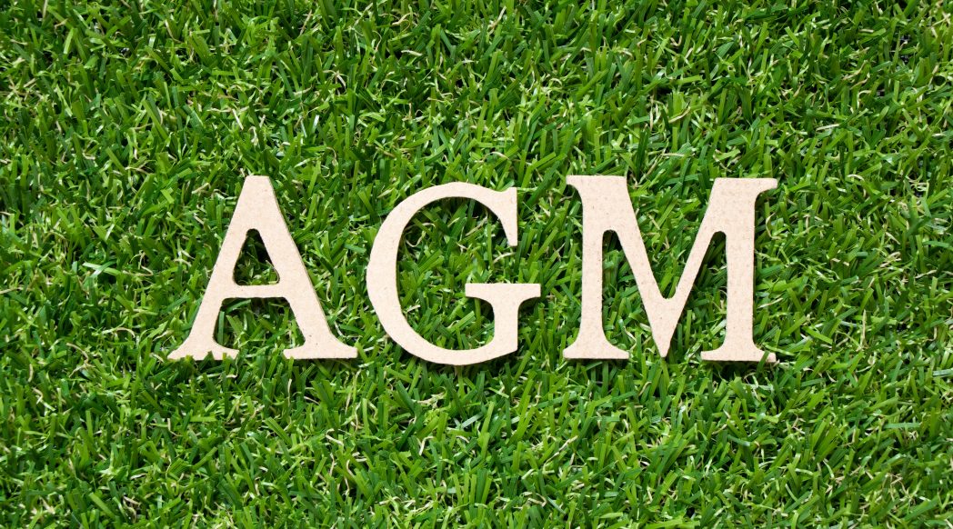 AGM written in letters on grass background